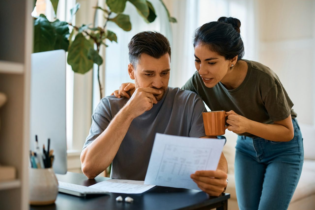 mid-adult-couple-analyzing-their-home-finances-at-home-.jpg